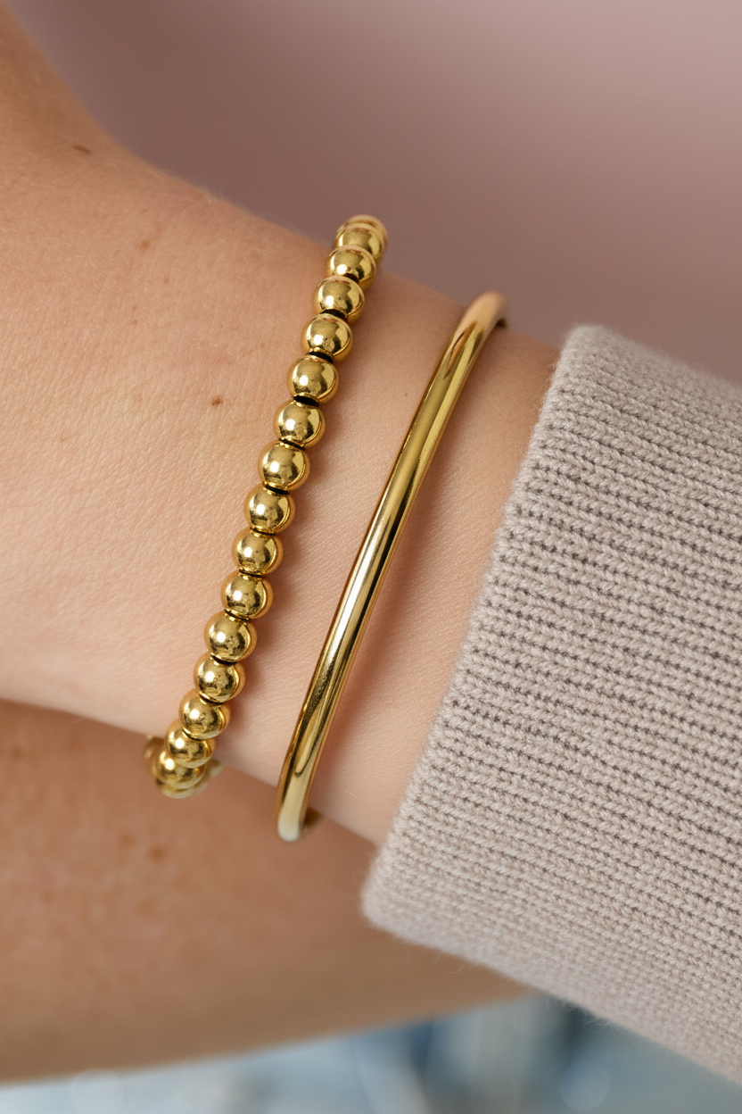 Gouden armbanden met gebreide trui